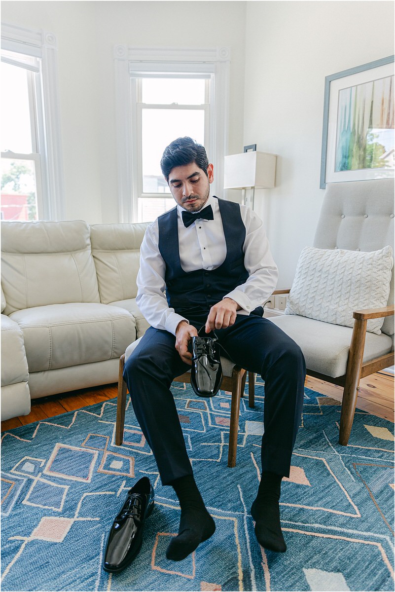 Groom puts on shoes for Maine Coastal Wedding