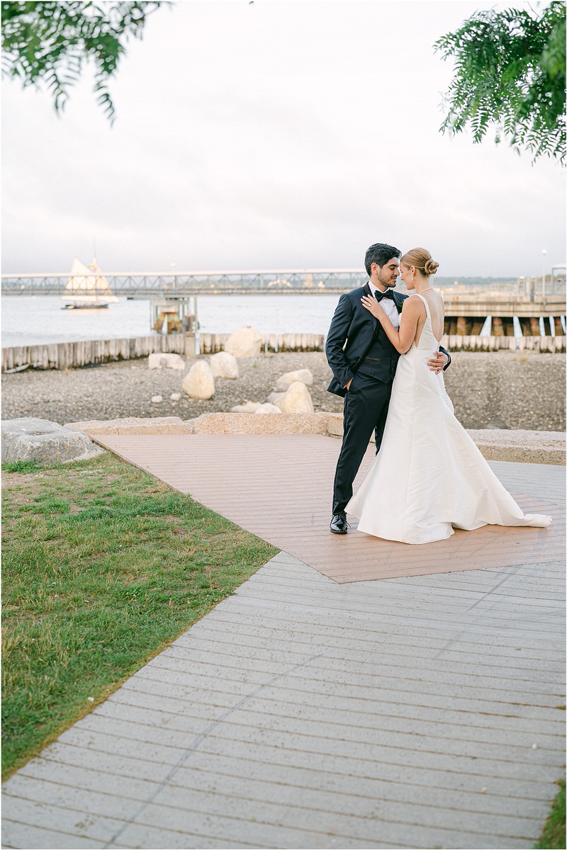 Man and woman hold one naother close with views of Maine coast for Rachel Campbell Photography