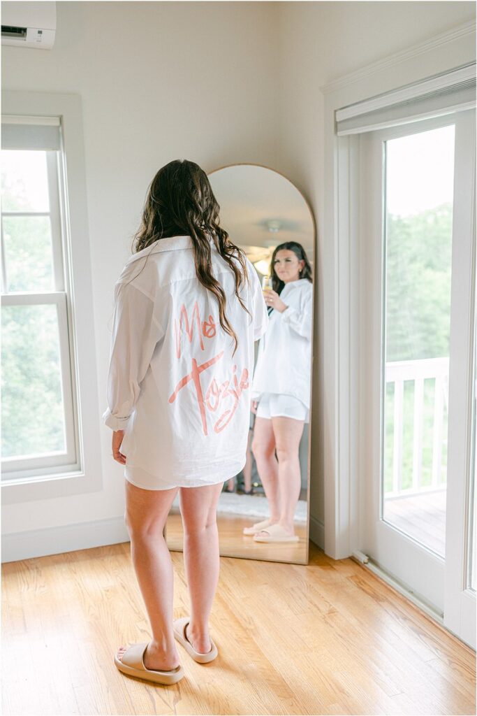 Bride admires self in mirror before Owls Head, ME Wedding 