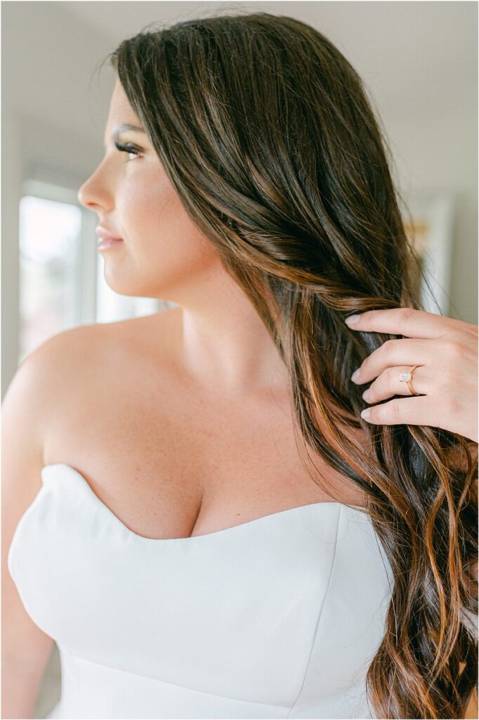 Bride pulls hair back before Owls Head, ME Wedding 