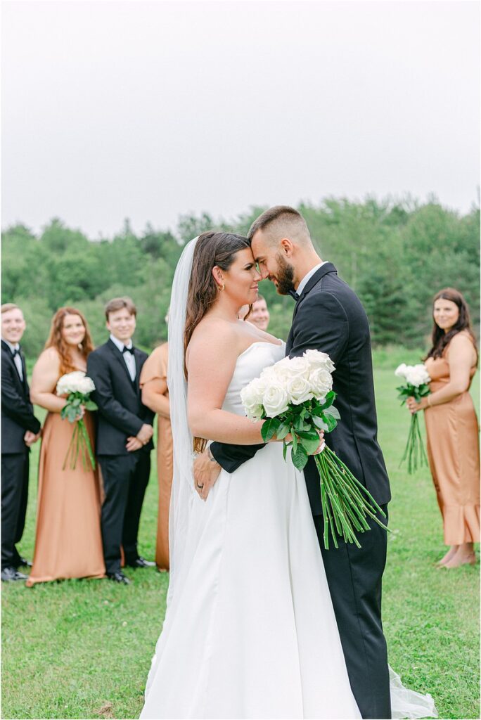 Bride and groom stand in front of wedding party for Summer Maine Wedding