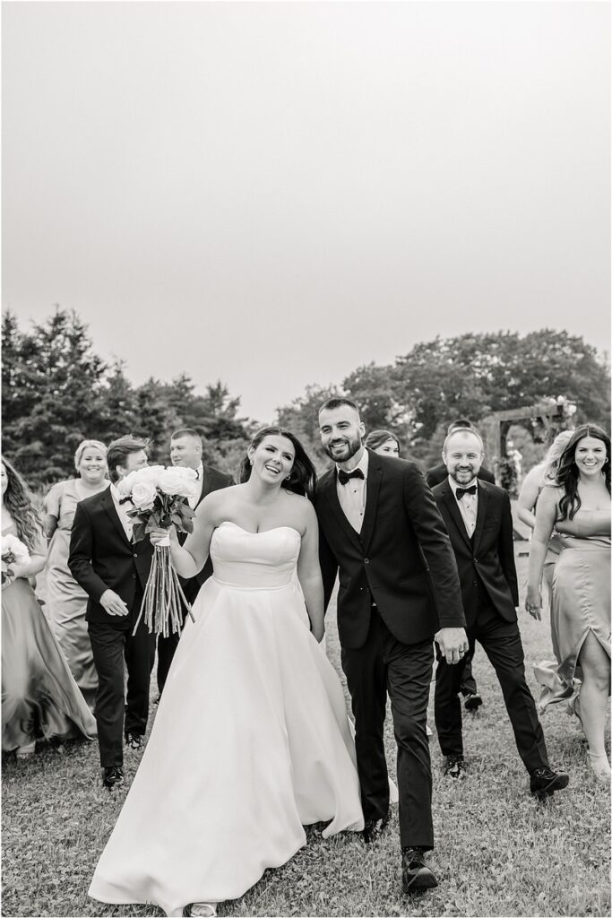 Husband and wife walk hand in hand together for Maine Barn Wedding