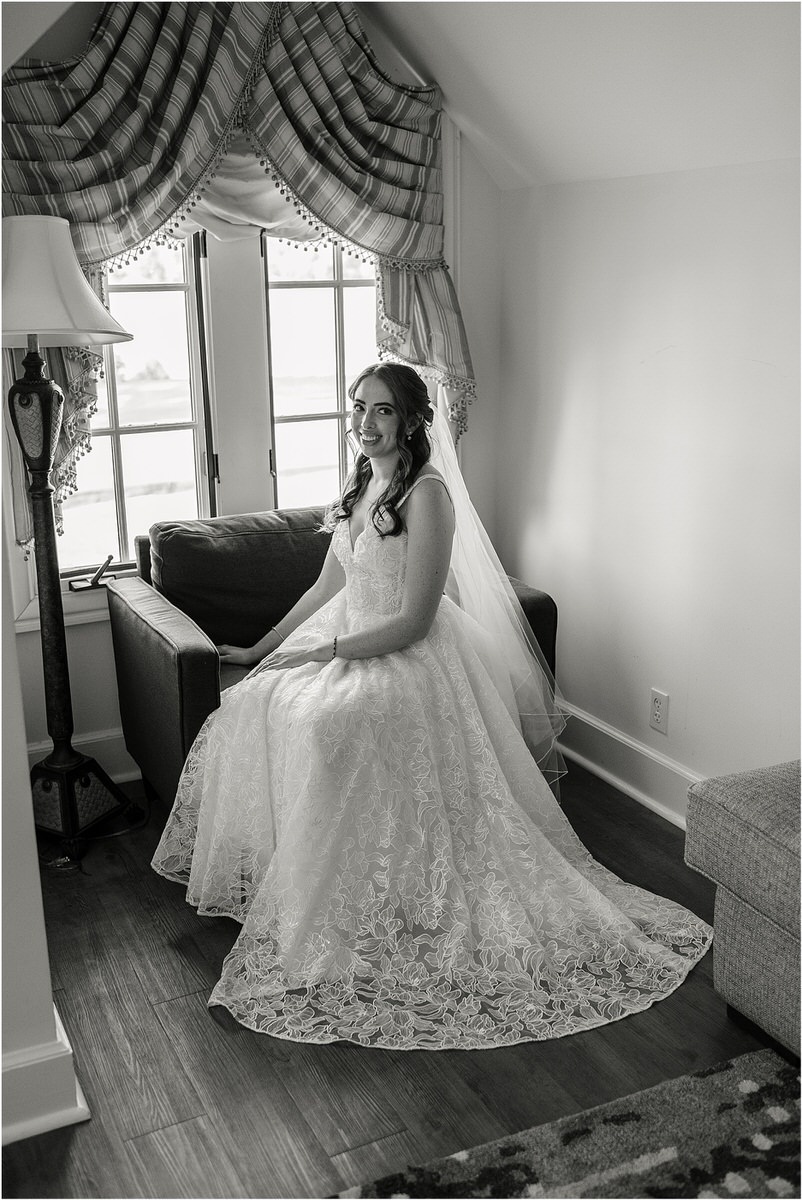 Bride sits on chair with her wedding gown on for wedding at Bar Harbor Club