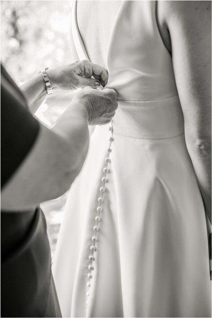 Mother helps bride with bridal gown at Beech Ridge Barn