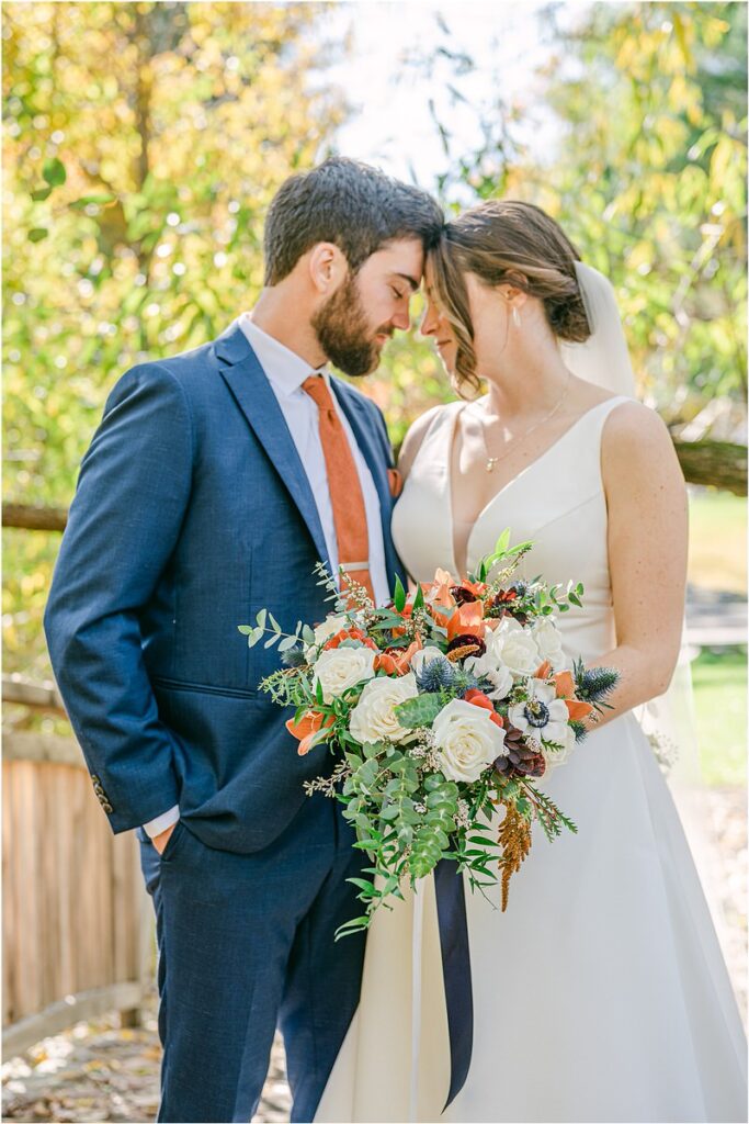 Husband and wife stand close together at Beech Ridge Barn
