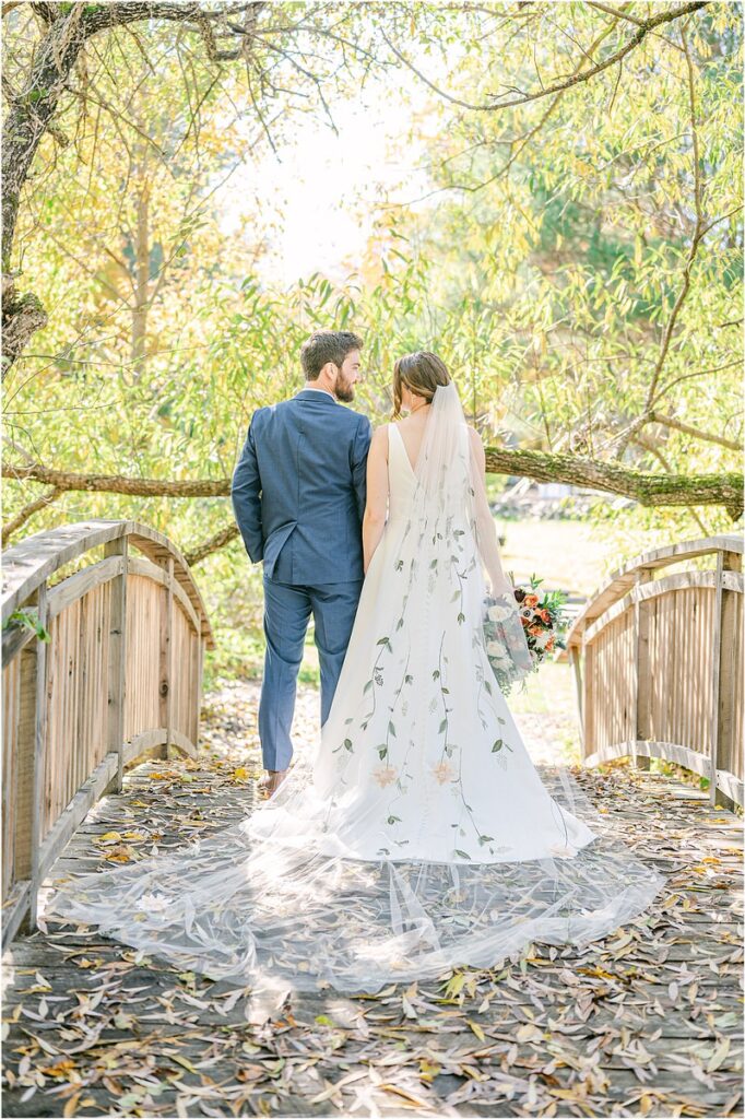 Couple walk hand in hand at Beech Ridge Barn