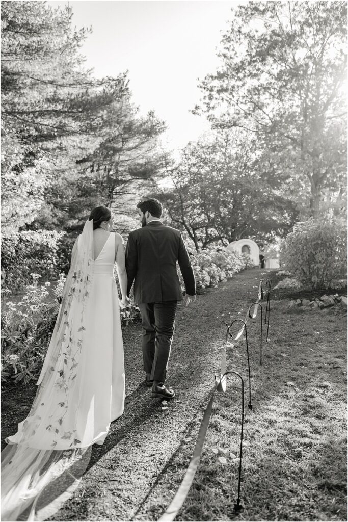 Couple walk hand in hand at Beech Ridge Barn