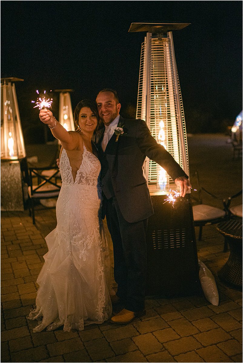Man and woman celebrate together with sparkler exit by Rachel Campbell Photography