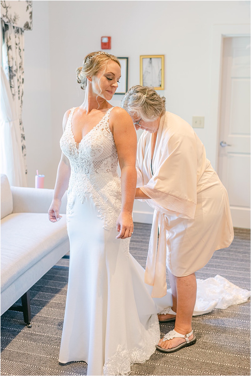 Bride gets dressed in bridal gown at Spruce Point Inn