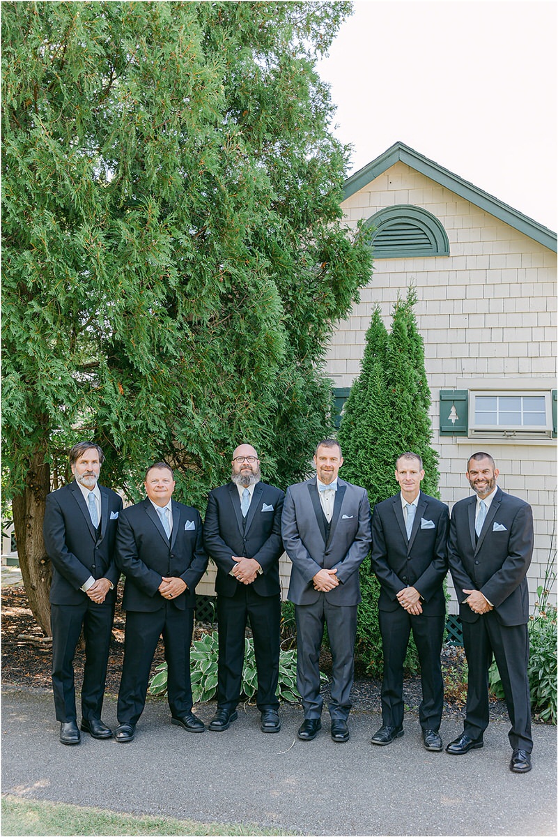 Groom and groomsmen stand together at Spruce Point Inn