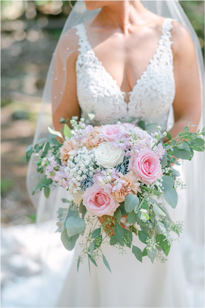 Bride holds bouquet at Spruce Point Inn