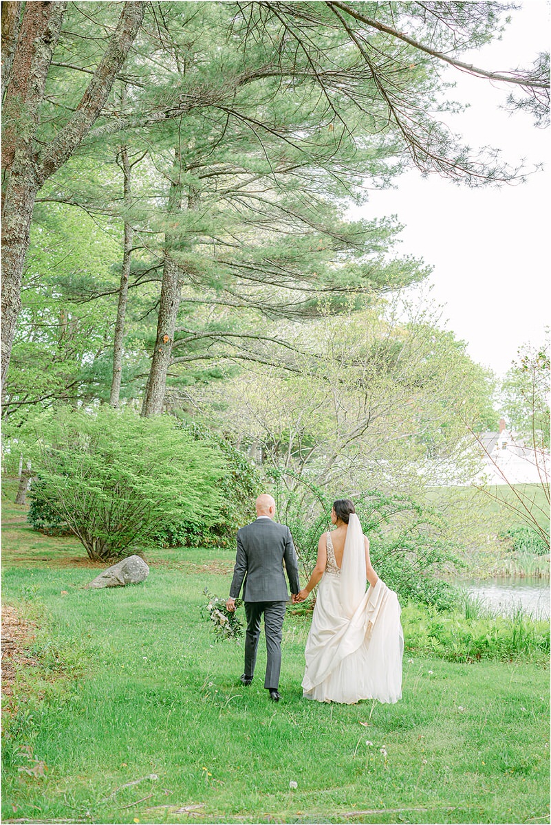 Bride and groom walk hand in hand together for New England Wedding Photographer