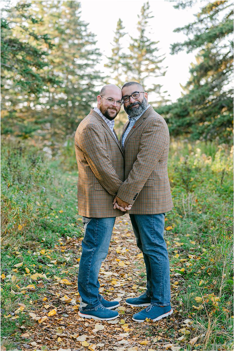 Two men hold hands together before their Maine fall elopement