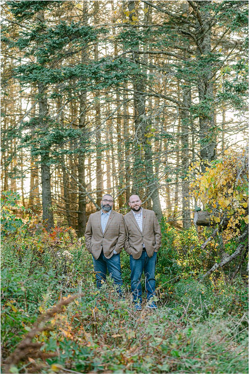 Couple stand together in the trees before their Maine fall elopement