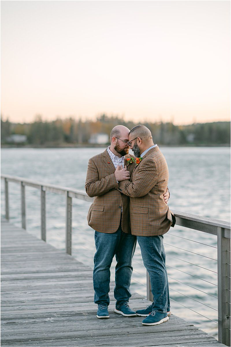 Two men hold each other close before their Maine fall elopement