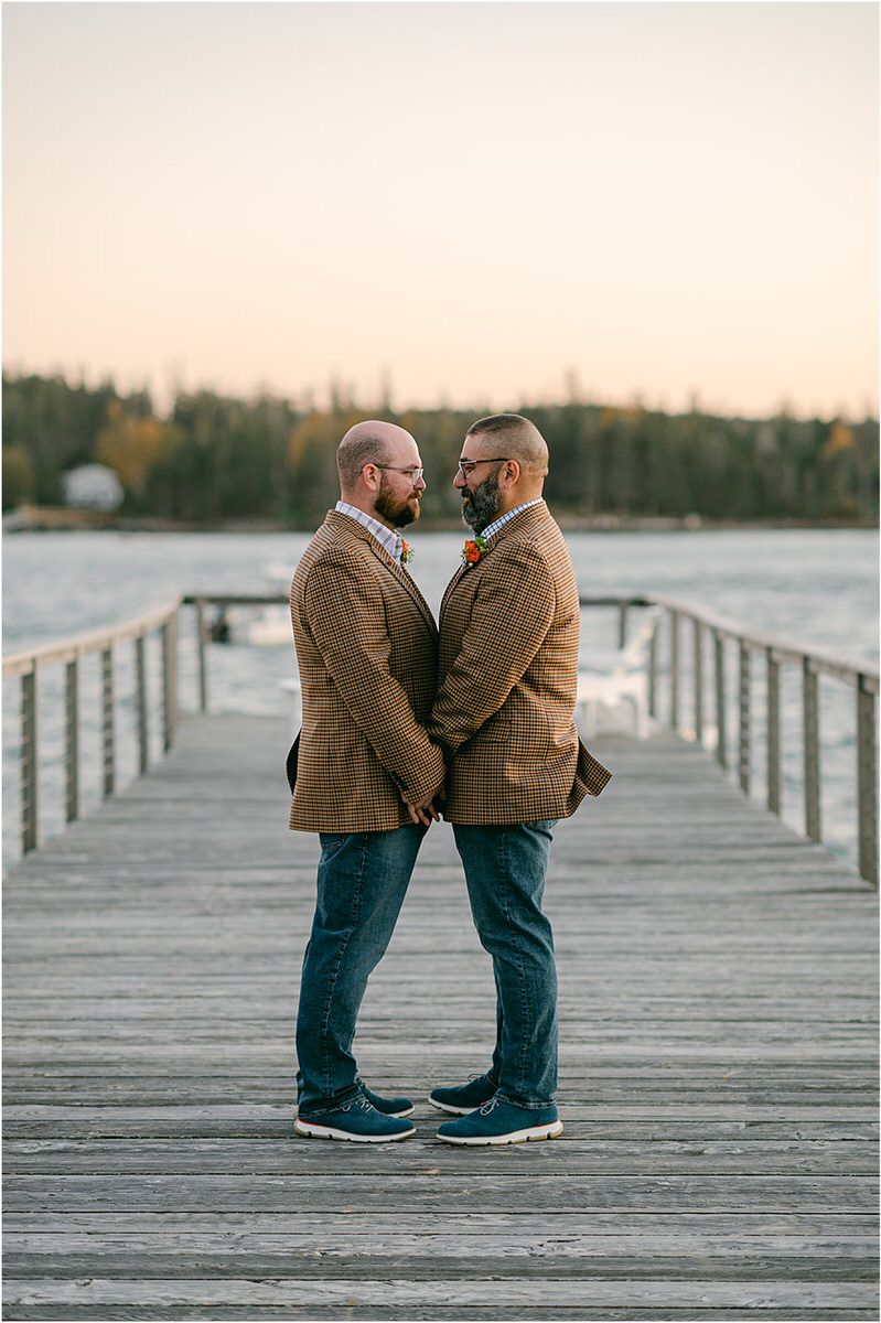 Two men hold each other close before their Maine fall elopement