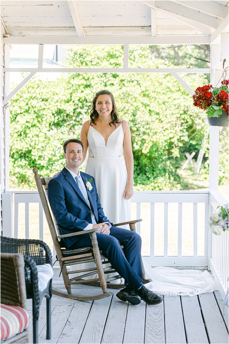 Groom sits on rocking chair next to bride at Portland's Ocean Gateway