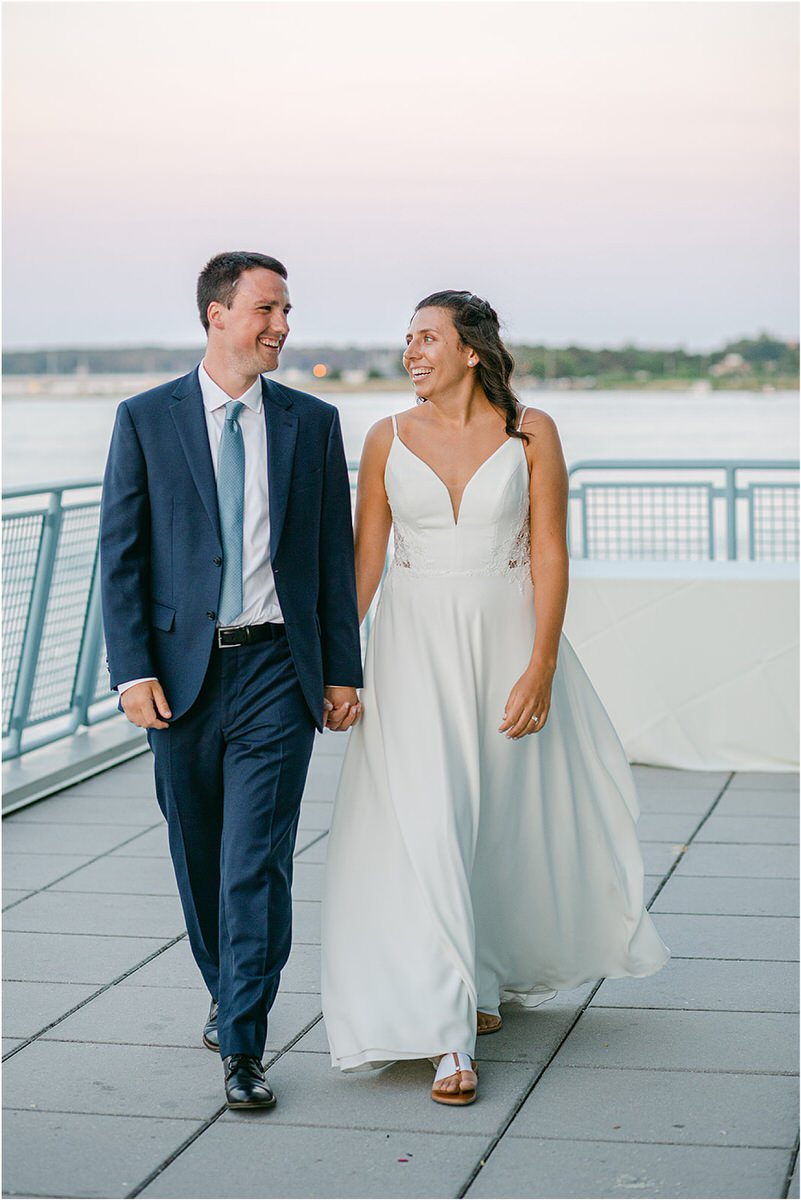 Couple walk together and smile at one another for Rachel Campbell Photography