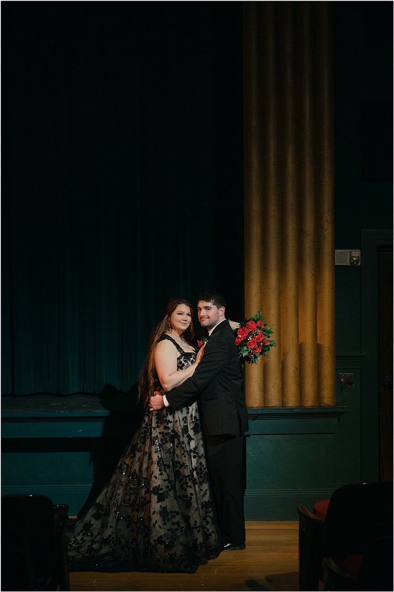Bride and groom stand together at The Strand Theatre