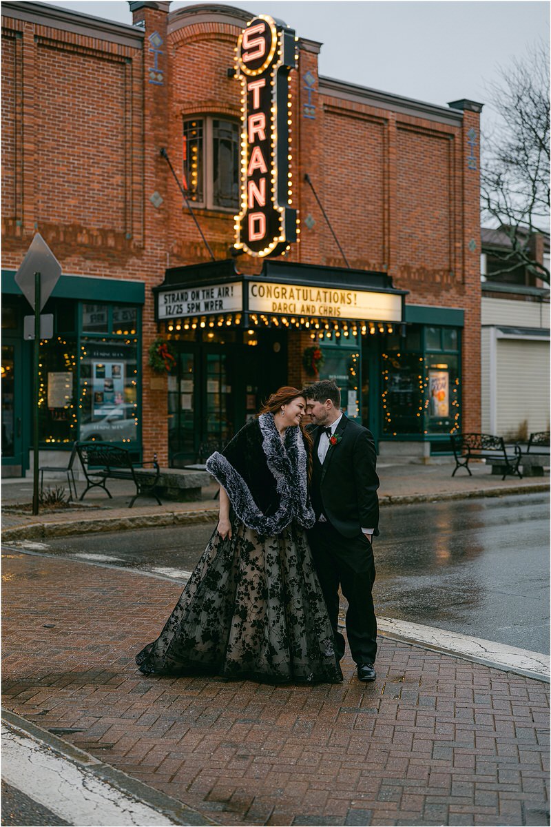 Couple stand together in front of the theatre for Rachel Campbell Photography