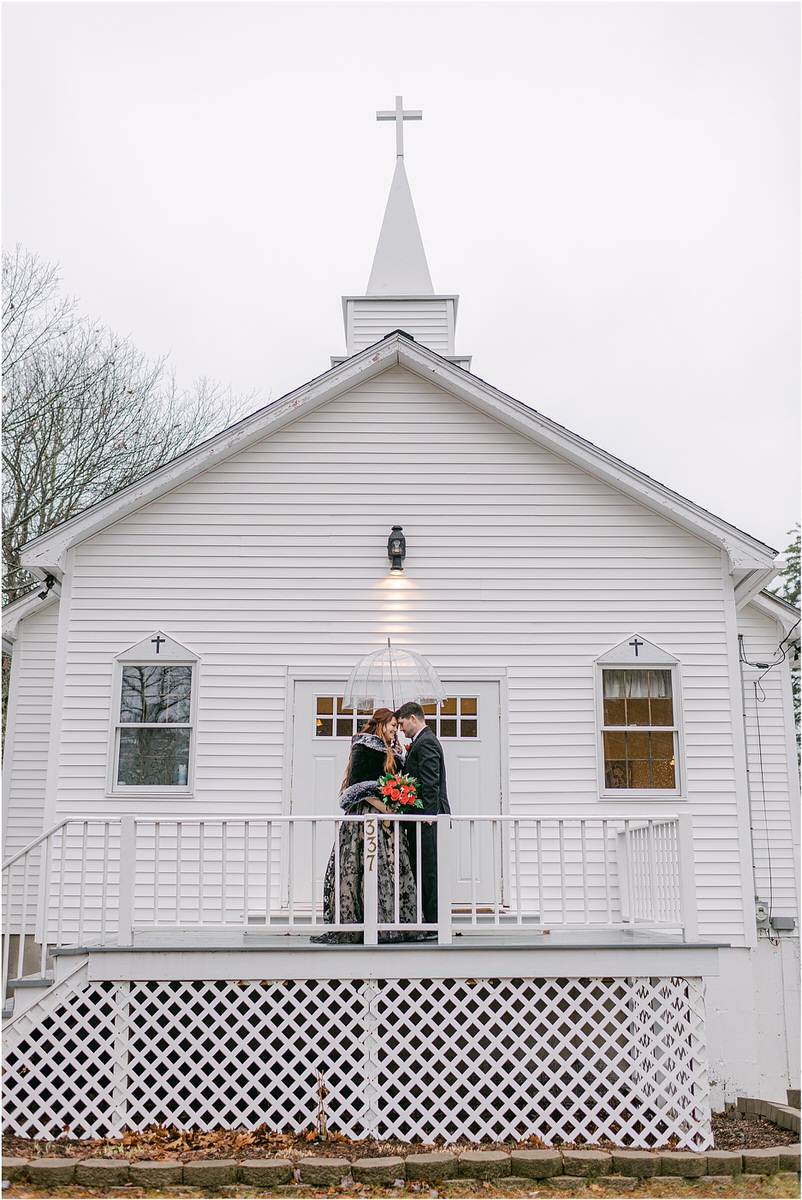 Couple share a kiss in front of a church for Rachel Campbell Photography