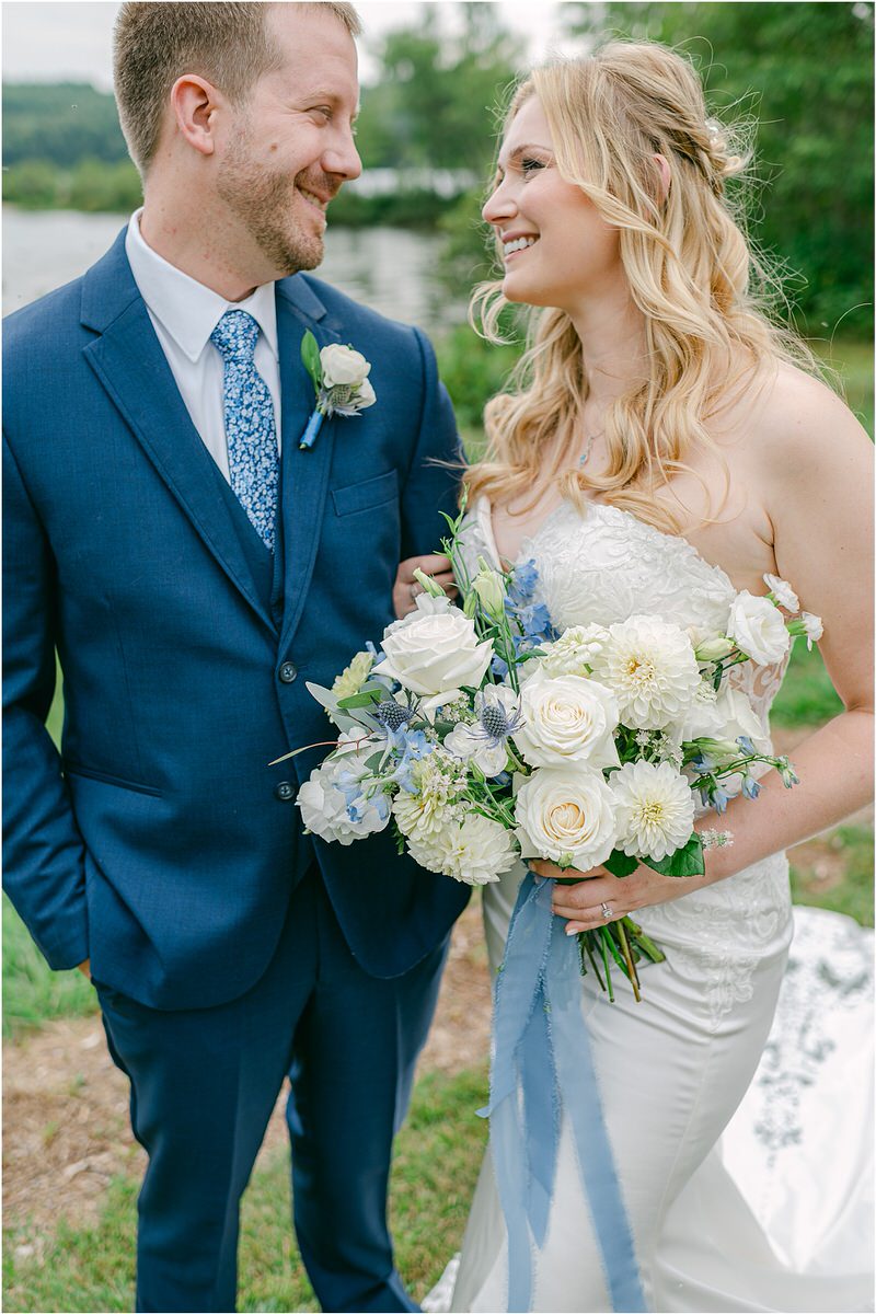 Bride and groom smile at one another at Bear Mountain Inn