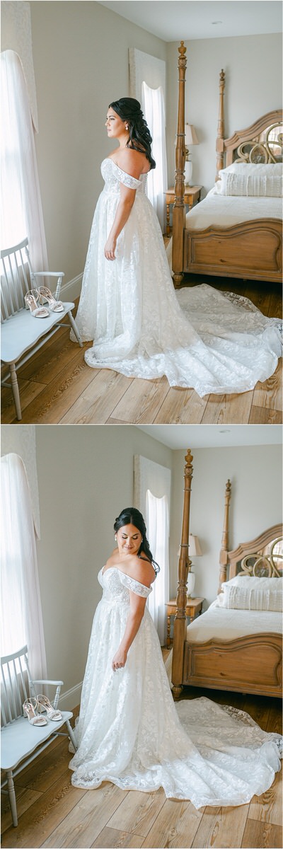 Bride smile in front of a window wearing her bridal gown at The Red Barn at Outlook Farm