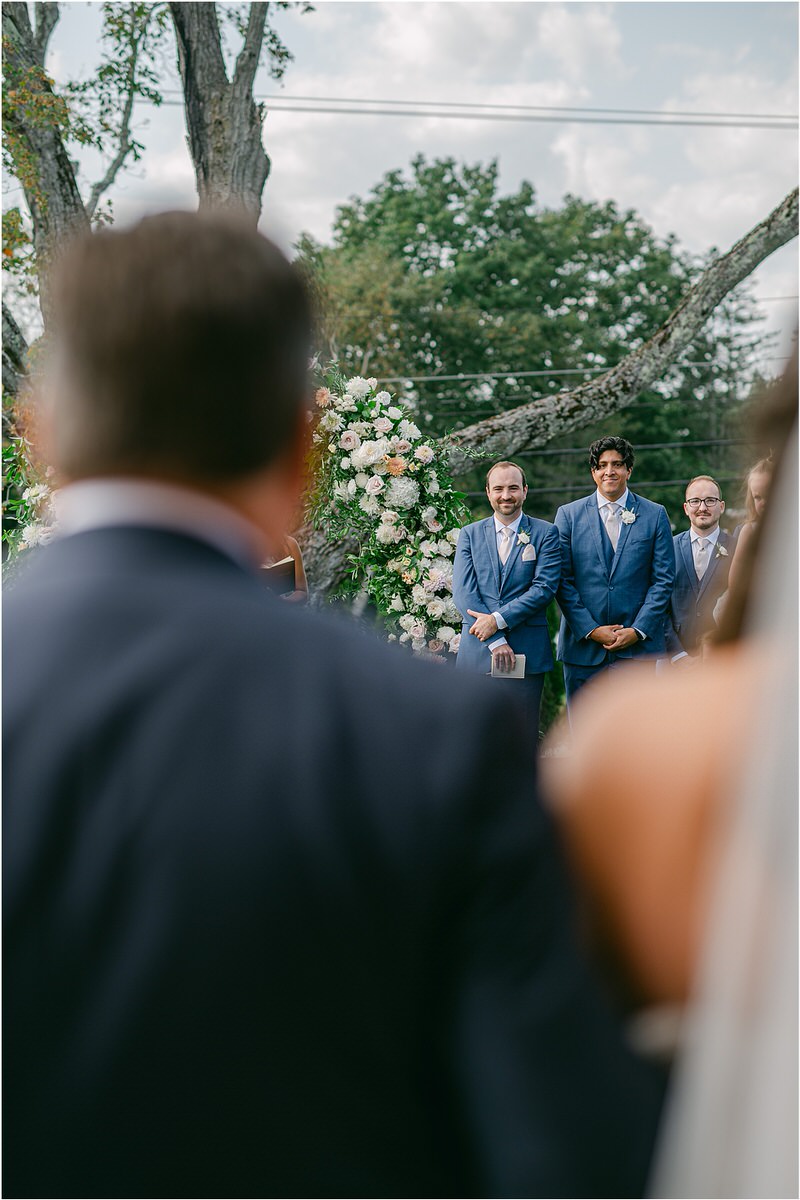 Groom sees the bride walking down the aisle at The Red Barn at Outlook Farm