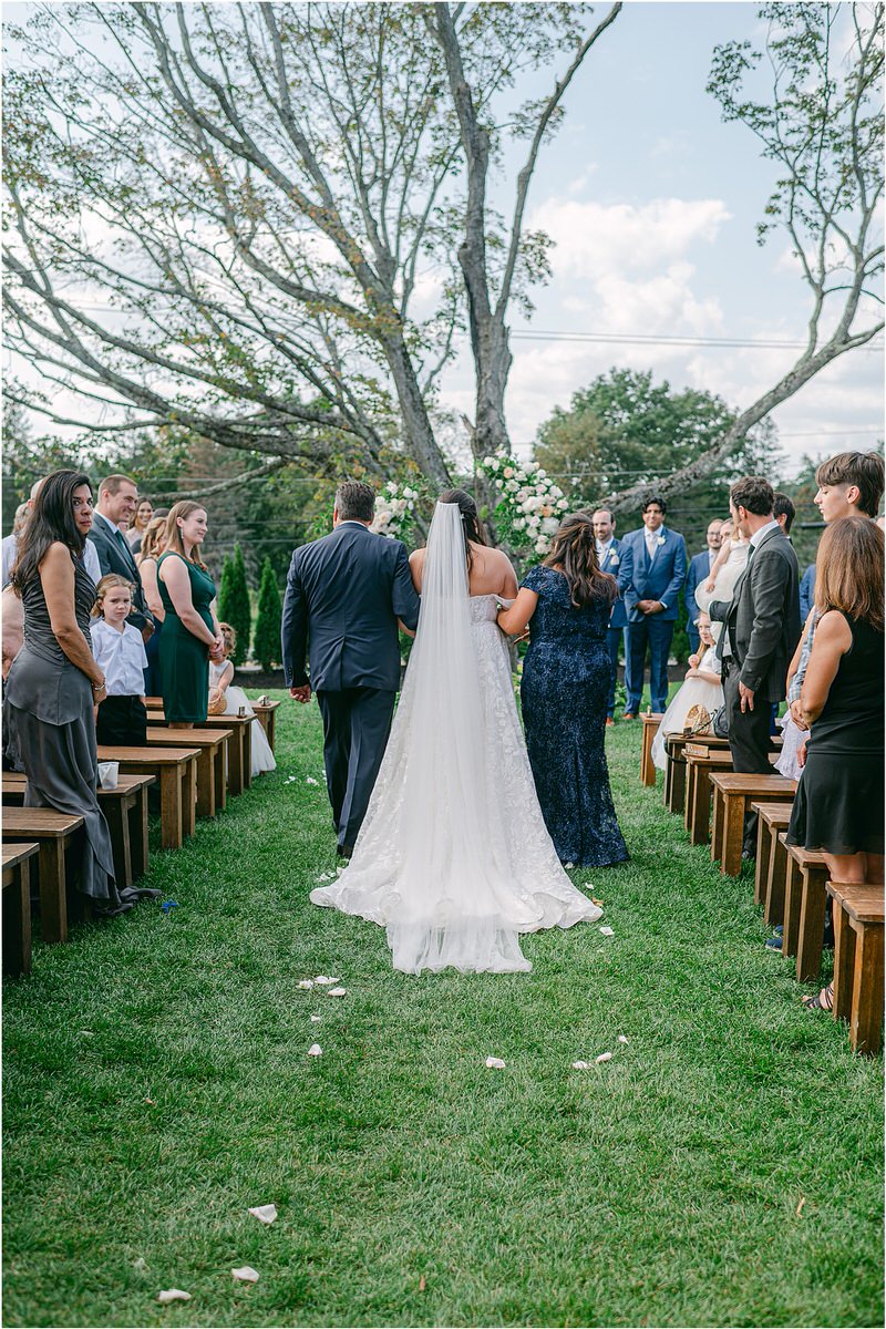 Parents walk bride down the aisle at The Red Barn at Outlook Farm