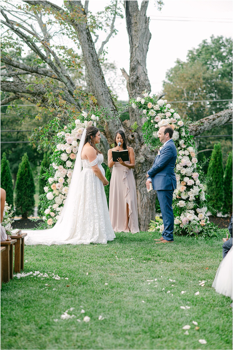 Couple stand at wedding altar at The Red Barn at Outlook Farm