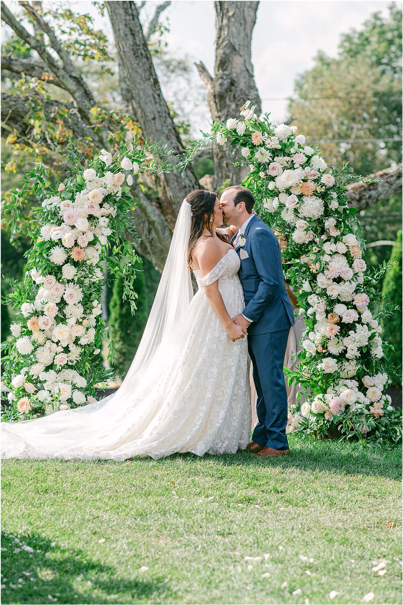 Bride and groom share a kiss at the altar at The Red Barn at Outlook Farm