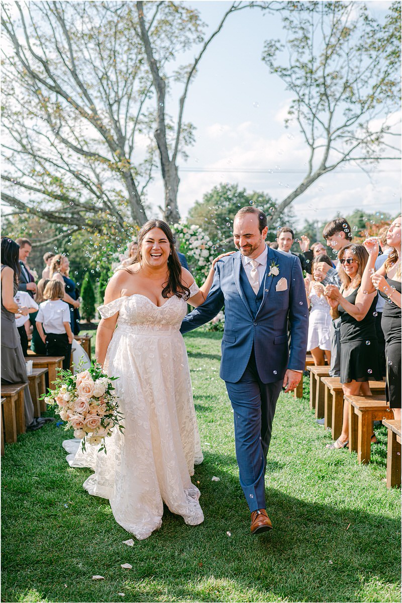 Bride and groom walk down the aisle at The Red Barn at Outlook Farm
